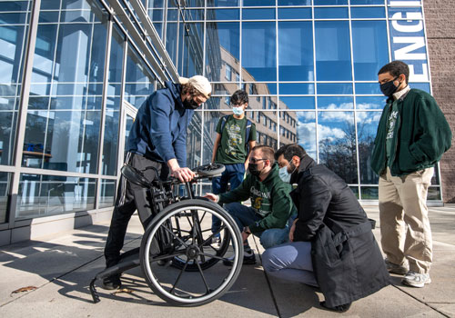Mason students work with motorized wheelchair basket on Fairfax Campus