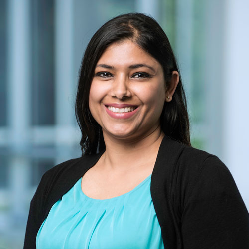 Kamaljeet Sanghera wears a light blouse and black sweater for her faculty profile in the IST department at George Mason University.