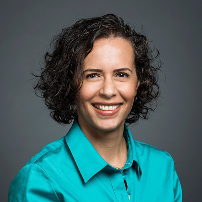 Dr. Özlem Uzuner wears a teal shirt and smiles in her faculty profile for the IST department at George Mason University.