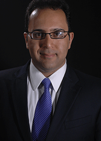 Ali Beheshti wears a dark suit, blue tie, and glasses in his faculty profile for the Department of Mechanical Engineering.