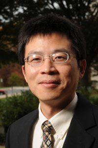 Songqing Chen wears glasses and a black suit for his faculty profile in the computer science department