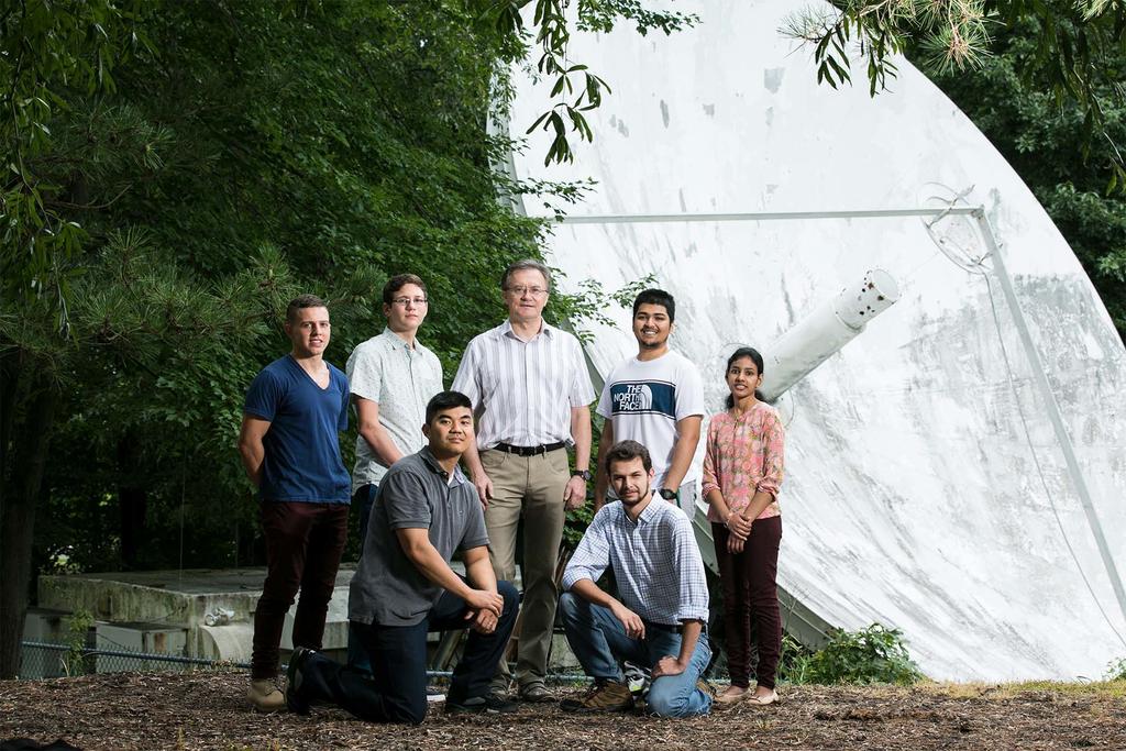 ECE associate professor Peter Pachowicz and students in front of a satellite dish
