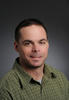 Mason associate professor Craig Lorie wearing a green, collared-shirt in his faculty profile